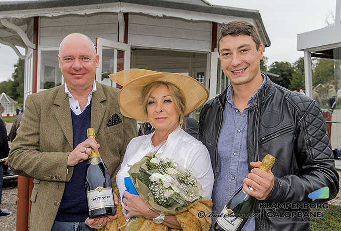 Opdrætter Marc Elsborg og Laila Jeppesen modtager ærespræmie efter Desert Eagles sejr udsat og overrakt af Tom Glæsner, en flaske Taittinger Champagne. Foto Burt Seeger Opdrætter Marc Elsborg og Laila Jeppesen modtager
ærespræmie udsat og overrakt af Tom Glæsner, en flaske Taittinger Champagne. Foto Burt Seeger