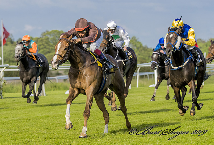 Prince Charming (SWE) med Carlos Lopez på vej mod klassisk sejr i Dansk 2000 Guineas 2019 med Primacor i gul/blå farver efter sig som anden. Foto Burt Seeger Prince Charming (SWE) med Carlos Lopez på vej mod klassisk sejr i Dansk 2000 Guineas 2019 med Primacor i gul/blå farver efter sig som anden. Foto Burt Seeger