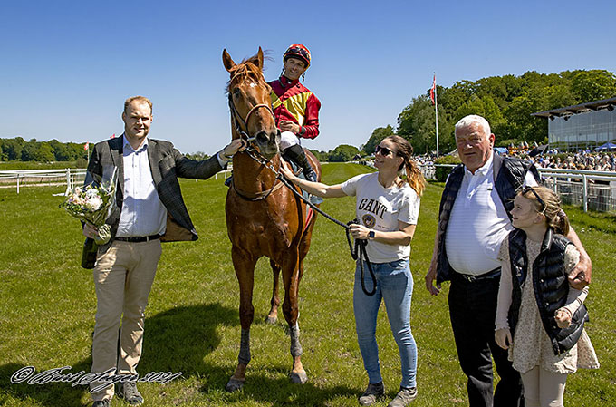 Peter Keller tager på vegne af Lone Kaj-Nielsen imod sejrsbuketten. Træner Bent Olsens barnebarn Caroline 
	er med på sidelinjen. Mor Christina Pedersen har styr på det hele. Foto Burt Seeger