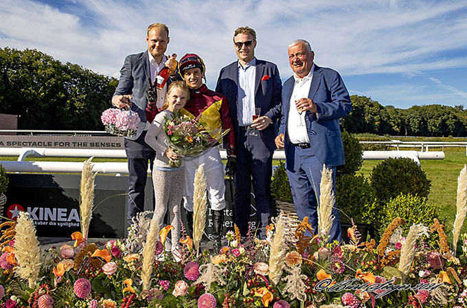 Træner Bent Olsen med barnebarn Caroline, jockey Elione Chaves, Lone Kajs nære Peter og Gustav Leth Keller i vindercirklen
		efter Great Wishs sejr i 3-Års Sprint på Damernes Dag, lørdag den 31. aug. 2024. Foto Burt Seeger