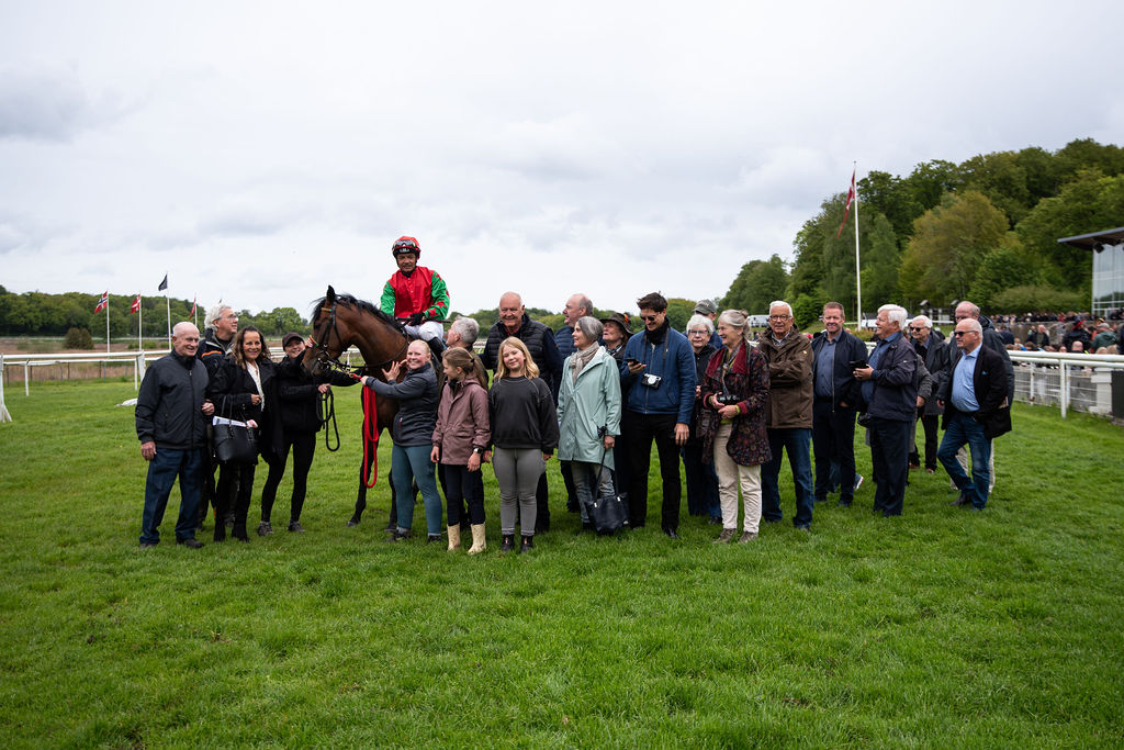 Ejerkredsen bag Cool Magics sejr, redet af Carlos Lopez,  samlet på græsset foran vindercirklen lørdag den 16. maj 2026.Foto: Johanna Friberg - https://fribergpics.pixieset.com/